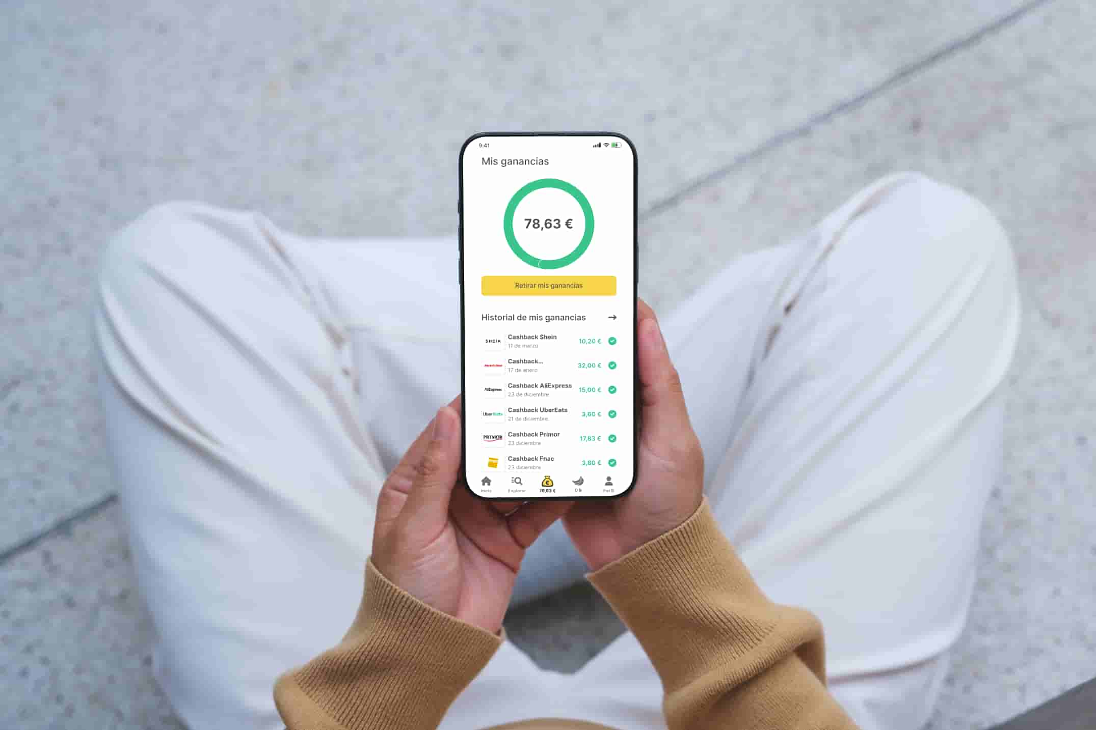Alguien sujetando el móvil desde el punto de vista de su cabeza con 70€ de cashback acumulados