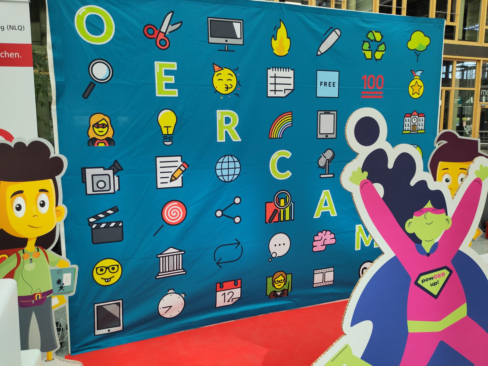 Foto: Wand mit verschiedenen Symbolen im Comic-Stil gezeichnet. Von links oben nach rechts unten diagonal Buchstaben, die das Wort OERCAMP bildern.