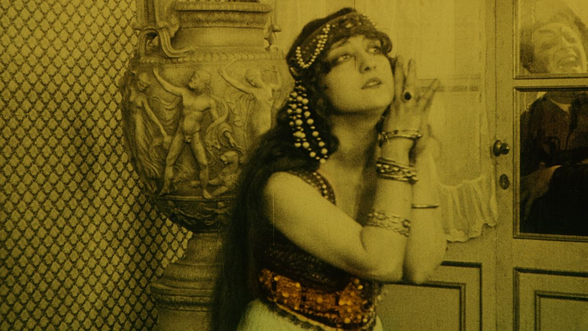 Main character of Satan's Rhapsody next to a window with Satan cackling behind it