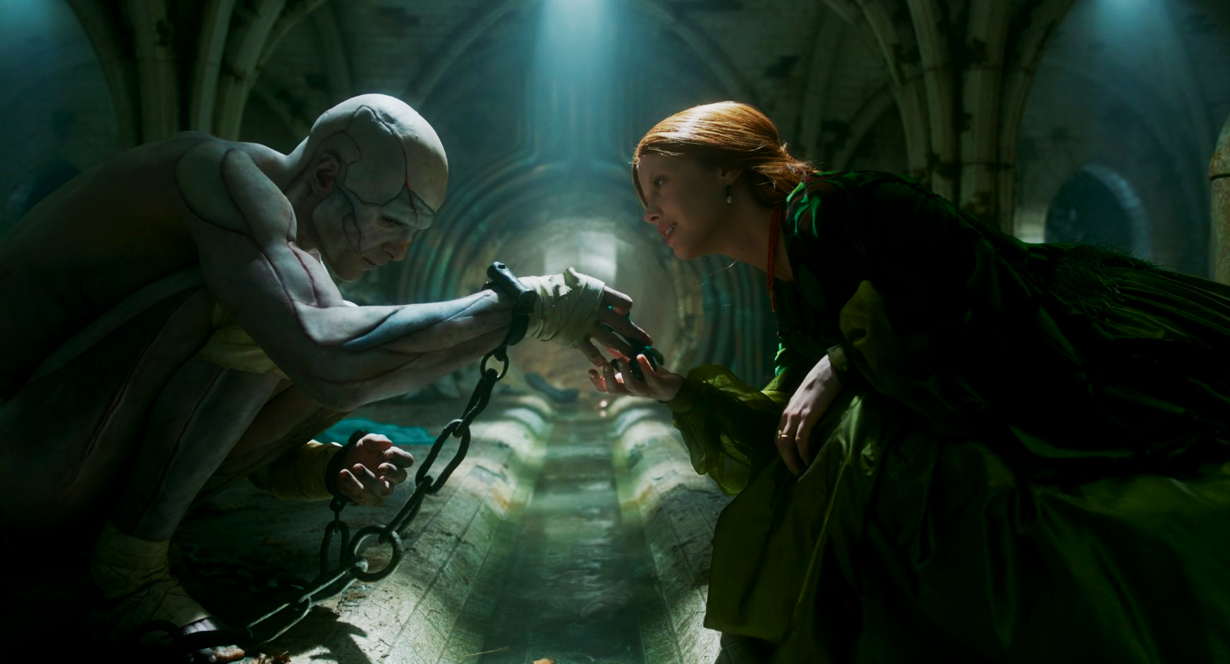 The Creature and Elizabeth reach towards each other over a gutter.