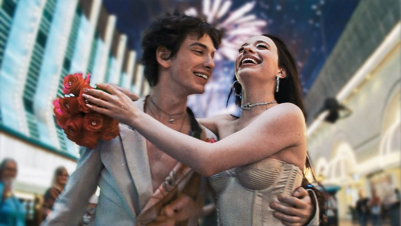 Still from Anora: Vanya (Mark Eydelshteyn) and Ani (Mikey Madison) embrace smiling in Las Vegas