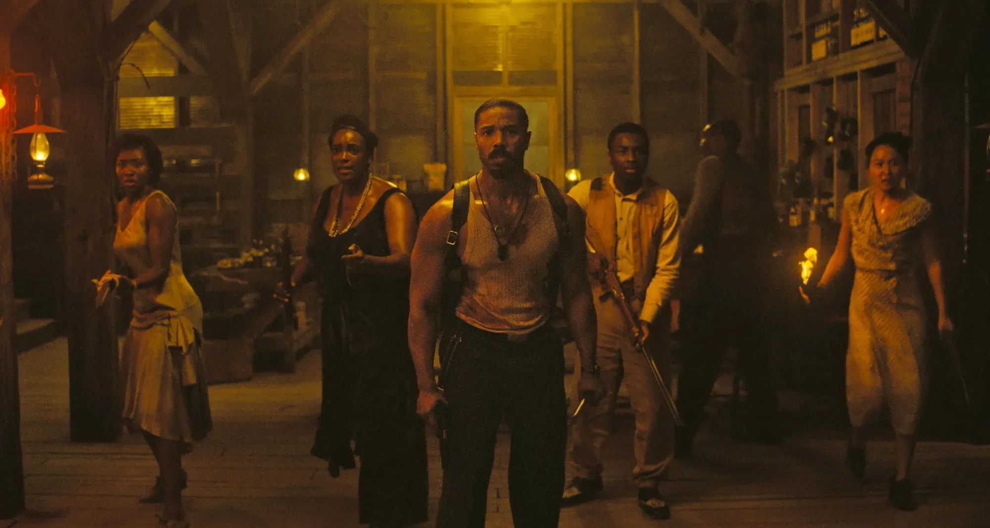 Still from Sinners: a group of people stand holding weapons