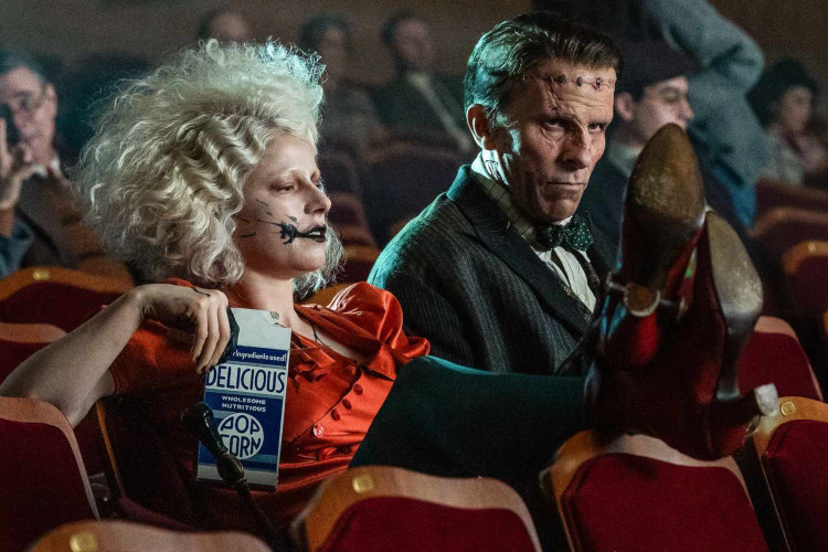 The Bride! (Jessie Buckley) and Frankenstein (Christian Bale) sit in a movie theater together with popcorn