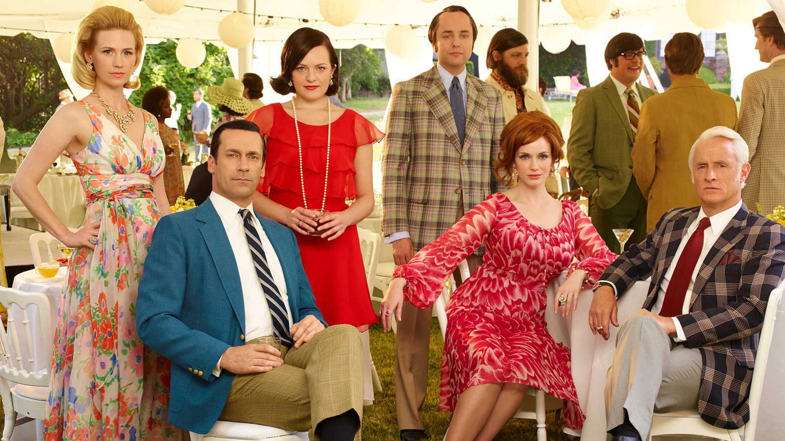 Cast photo of Mad Men: a group of the main characters sit in formal wear at an outdoor event.