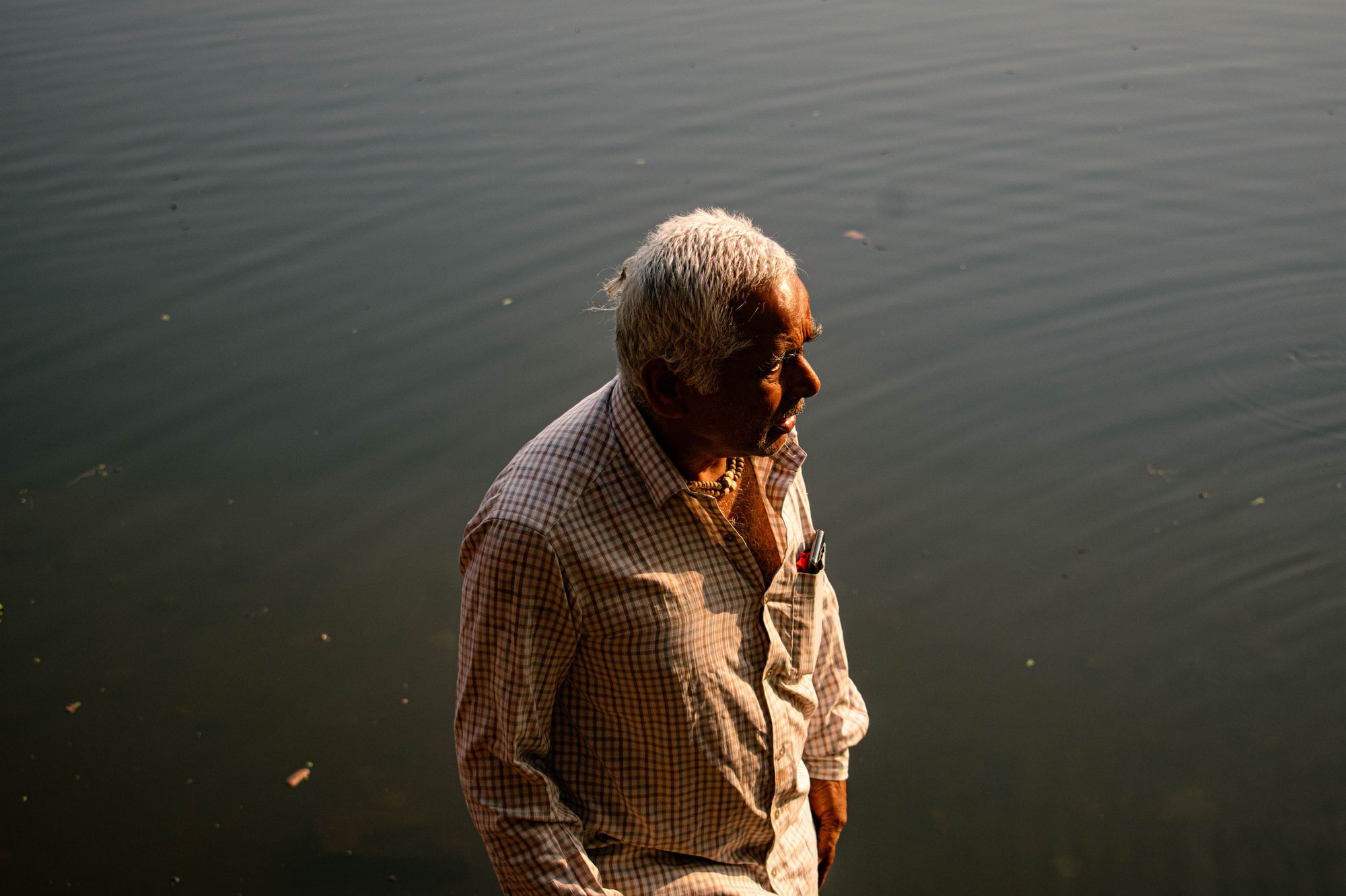 An Oldman standing near a Lake in the morning