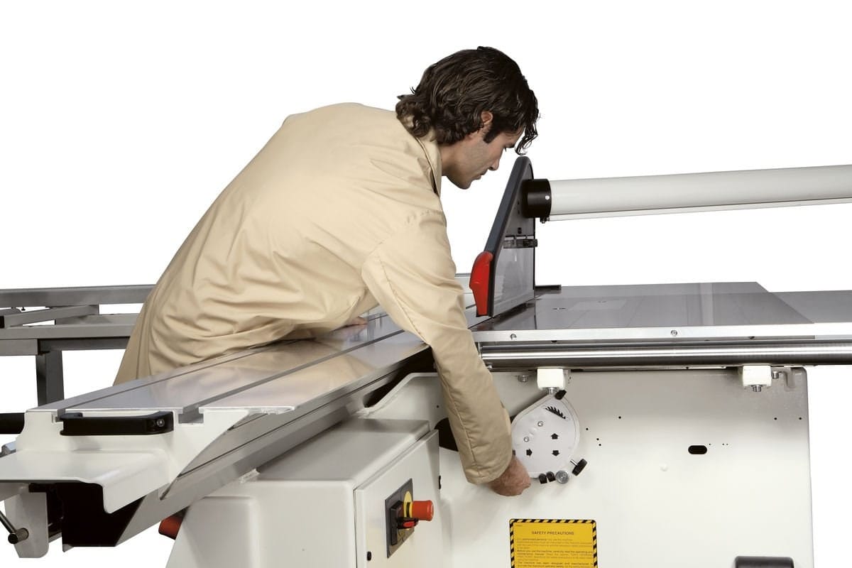 Operator profesionist care ajustează manual înclinarea pânzei pe un ferăstrău circular SCM Minimax SI 400 într-un atelier de tâmplărie.