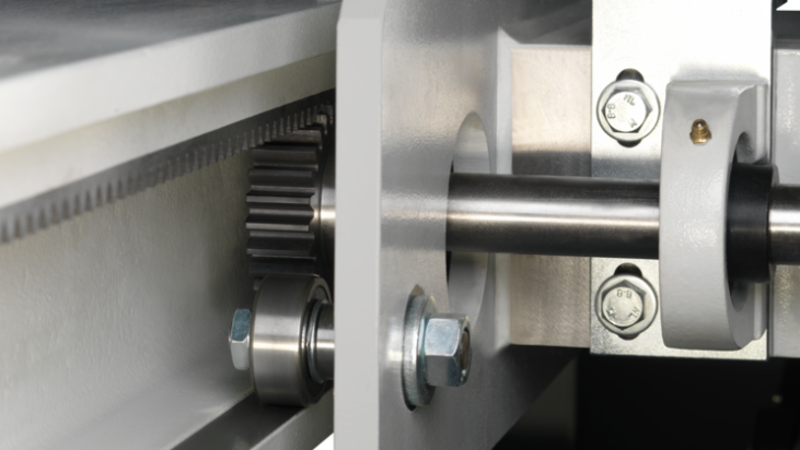 Detaliu cu pânza principală și pânza incizoare a unui fierăstrău de debitat, tăind un pachet (stack) de trei panouri de PAL melaminat.