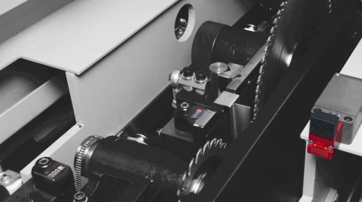 Detaliu al grupului incizor motorizat al unui fierăstrău de debitat, arătând mecanismul de reglare fină și senzorii de poziționare.