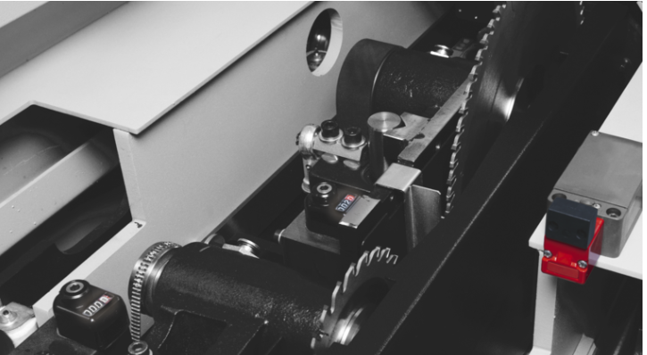 Detaliu al grupului incizor motorizat al unui fierăstrău de debitat, arătând mecanismul de reglare fină și senzorii de poziționare.