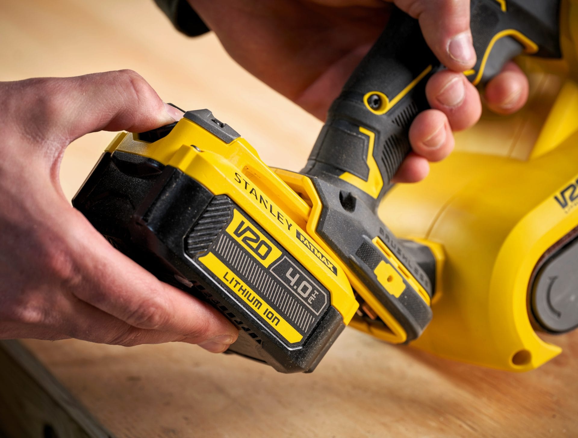 Detaliu cu rindeaua electrică pe acumulator Stanley Fatmax V20 (SFMCW300B) executând un falț (lamba) pe muchia unei uși din lemn de pin.